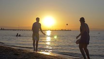 Couple playing racket ball at sunset