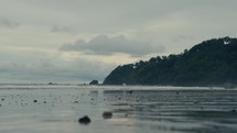 Water running over the sand of a tropical beach at dusk