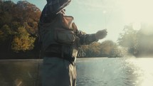 Young fly fisherman casting on a river on a fall morning