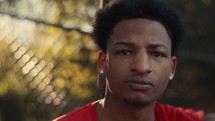 Portrait of a smiling young man playing basketball on a sunny day