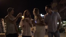 Friends toasting with coffee cups in night street