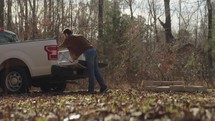 Man unloading bricks from a pickup truck and building an outdoor fire pit