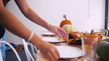 woman setting a table for Thanksgiving dinner 
