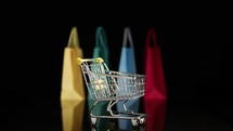 Shopping cart with blurred shopping bags background 