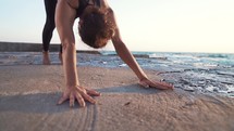  Woman practicing yoga on rock above sea at amazing sunrise. Fitness, sport, yoga and healthy lifestyle concept. Slow motion