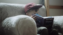 a toddler sitting reading books 