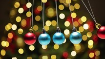Christmas Balls Swinging Pendulum Against Tree