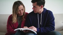 a couple reading a Bible together and praying 