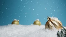 Gold Christmas ornaments composition under the snow 