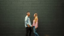 a couple talking in front of a gray background 