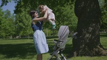 a mother lifting her daughter out of a stroller 