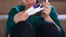 a woman looking at negative pregnancy tests