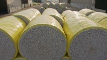 Large stacks of cotton bales at a cotton gin after harvest