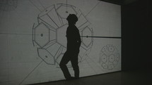 a man dancing in front of a projector 