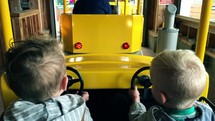 children riding on a yellow train ride 
