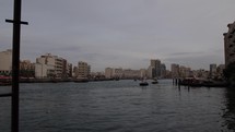Boats and buildings on the Old Dubai river in cinematic slow motion.