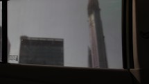 Looking at buildings and skyscrapers through car window while driving in middle eastern city of Dubai.