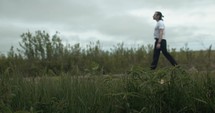 Young man walking on unpaved, dirt road on summer day explore, hiking, worshipping and praying. Lifestyle, worship and prayer concept.