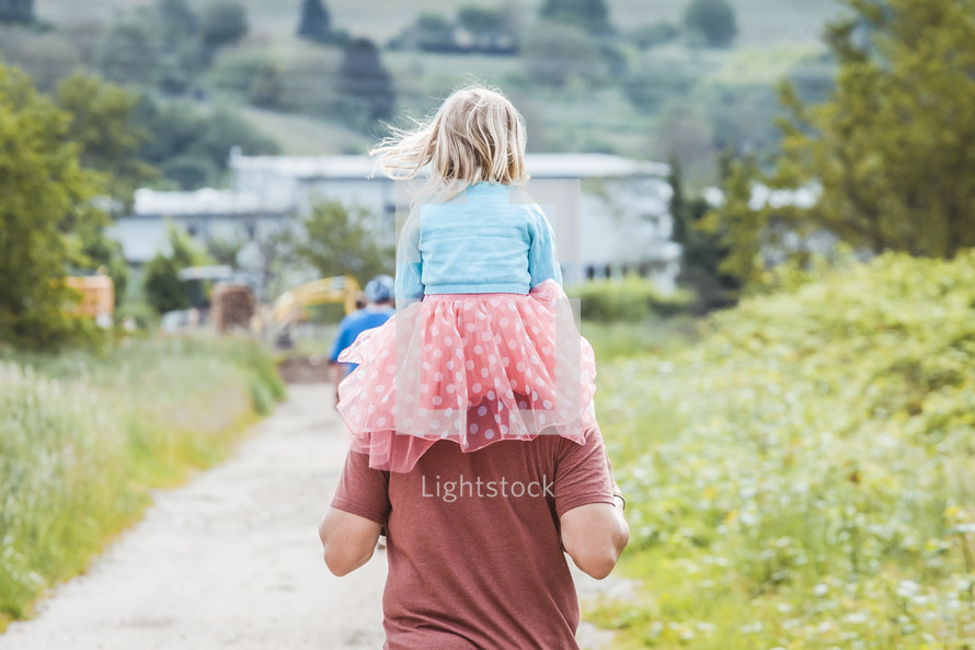 toddler girl in a tutu on father's shoulders 