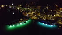 Party boat with illuminated hull docked in harbor of Split, Croatia. After dark, aerial night shot