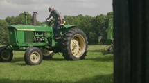 a farmer getting off of a tractor 