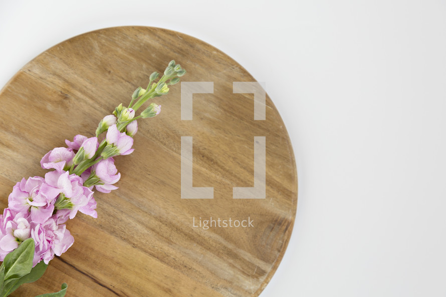 pink flowers on a wood cutting board 