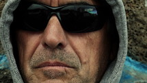 Man wearing a hoodie and sunglasses.