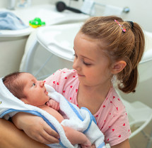 a sister holding a newborn 