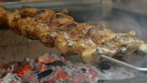 Chicken cooking over coals.