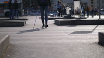 a blind man walking in a city 