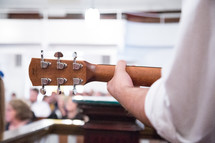 man playing a guitar during a worship service 