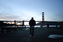 a man walking towards the Golden Gate Bridge 