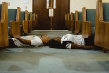 man and woman lying on a church floor 
