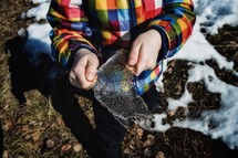 child holding a chunk of ice 