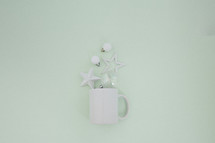 mug with white ornaments on mint green 