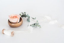 wood bowl, roses, and spool of ribbon 