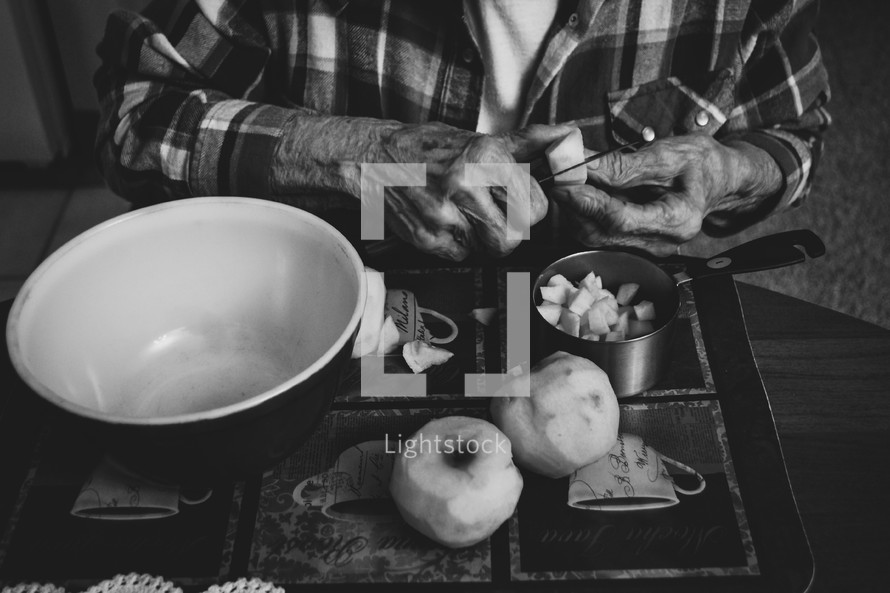 an elderly woman slicing apples 