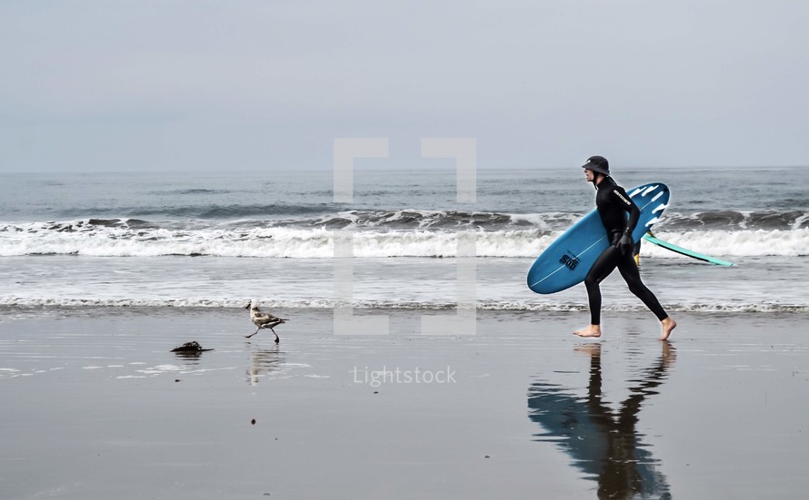 surfer walking on a beach 