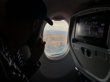 passenger looking out an airplane window 