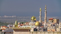 Large Islamic Mosque with golden turrets in an Muslim city