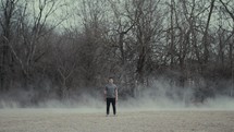 a man standing in a dusty field 