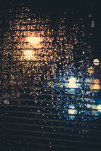 blinds and rain drops on a window at night 