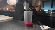 Pastry chef prepares raspberry sauce for cheesecake