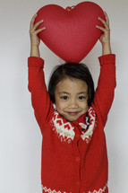 a child holding a red heart 