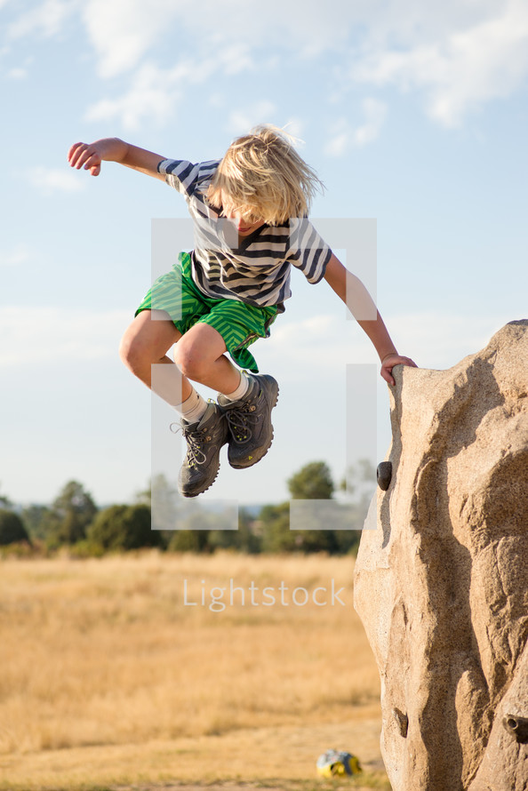 a boy child jumping outdoors 