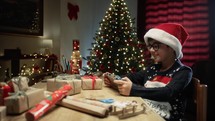 Boy using his Smartphone to show his Christmas tree 