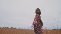 a woman walking through a field 
