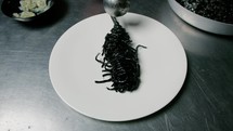 Chef Plating First Course Black Ink Cuttlefish Spaghetti At Restaurant