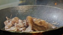 Slow motion of roast beef cooked in a frying pan with flames