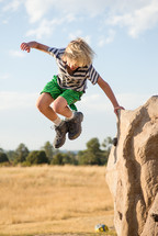 a boy child jumping outdoors 